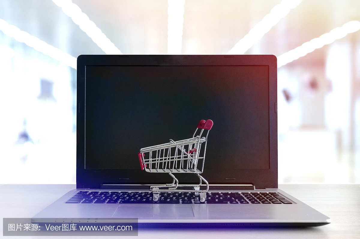 網(wǎng)上購(gòu)物概念:筆記本電腦上的迷你購(gòu)物車